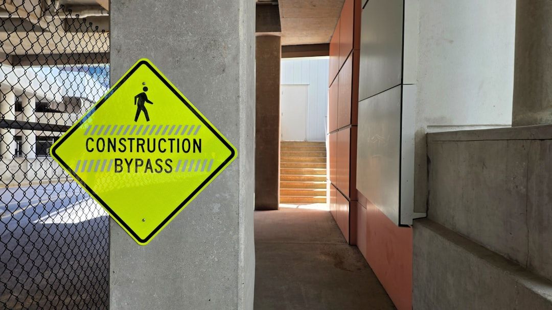 Yellow construction bypass sign on concrete pillar